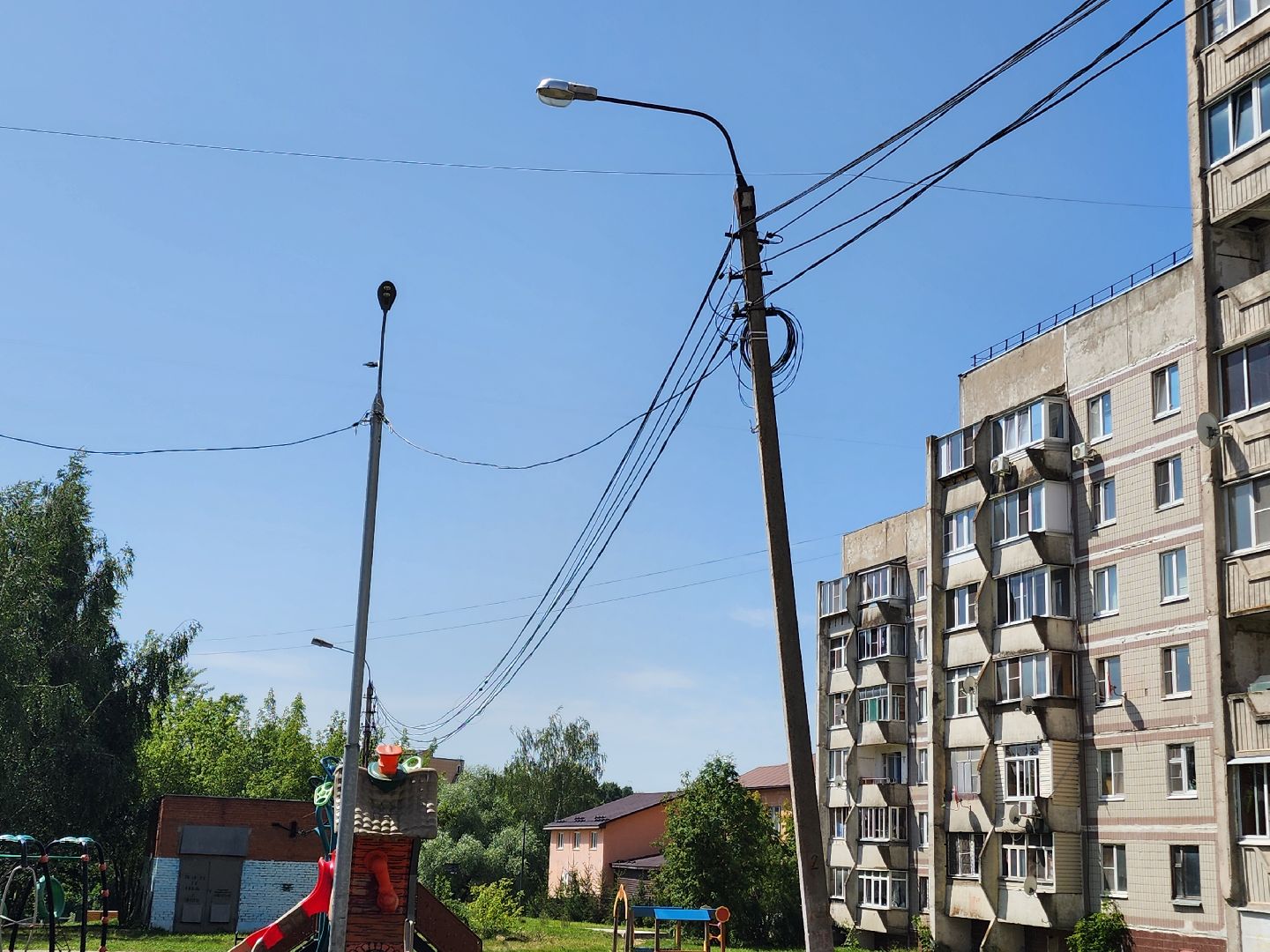 чехов,  улица береговая 39, детская площадка, опора освещения, наклонившийся столб, провода над детской площадкой, устранить проблему, мбу чеховское благоустройство, нависающие провода, обращения жителей,